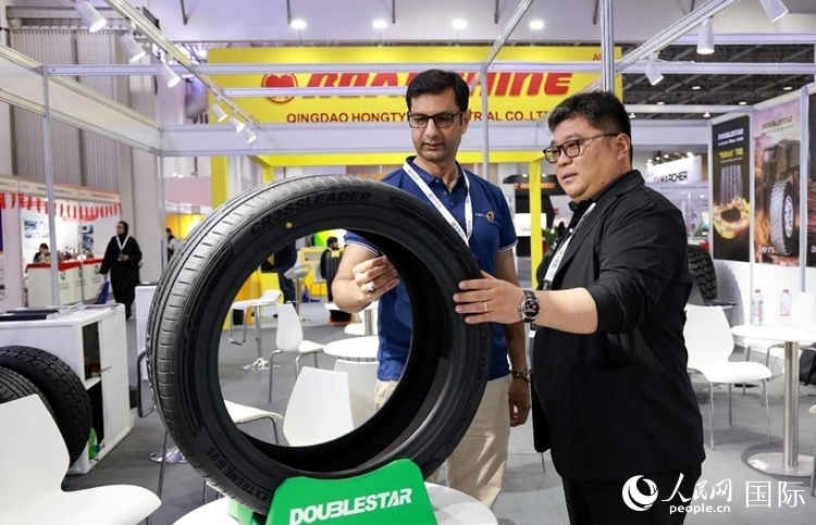 工作人員向客戶展示雙星電動汽車輪胎。和傳統(tǒng)汽車輪胎相比，電動汽車輪胎具有更高承載能力、更加靜音舒適、更好極速抓地、更低滾動阻力等特點。人民網(wǎng)記者 管克江攝