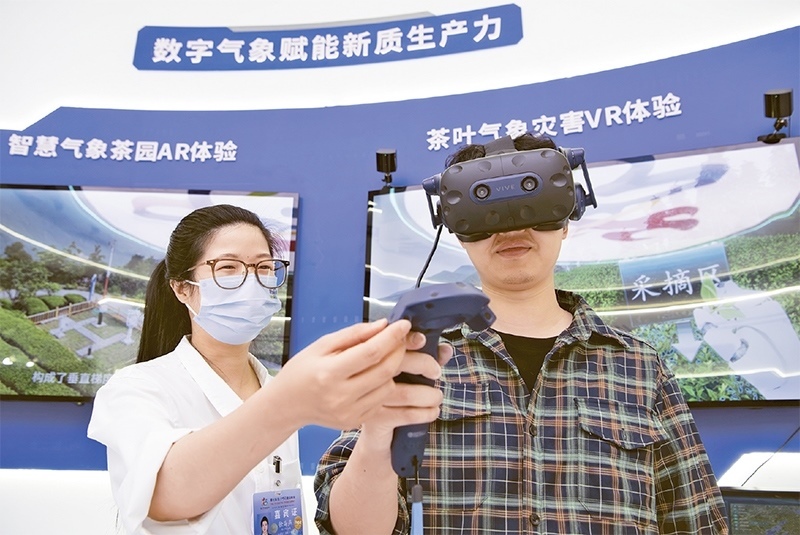 2024年5月23日，第七屆數(shù)字中國(guó)建設(shè)峰會(huì)現(xiàn)場(chǎng)體驗(yàn)區(qū)在福州海峽國(guó)際會(huì)展中心向?qū)I(yè)觀眾開(kāi)放。本次現(xiàn)場(chǎng)體驗(yàn)區(qū)圍繞本屆峰會(huì)主題“釋放數(shù)據(jù)要素價(jià)值，發(fā)展新質(zhì)生產(chǎn)力”，設(shè)置“數(shù)字惠民”、“數(shù)字能力”、“數(shù)字基礎(chǔ)”、“數(shù)字生態(tài)”、“數(shù)字賦能”五大板塊。圖為一名觀眾（右）在數(shù)字氣象賦能新質(zhì)生產(chǎn)力展臺(tái)上進(jìn)行體驗(yàn)。 新華社記者 魏培全/攝