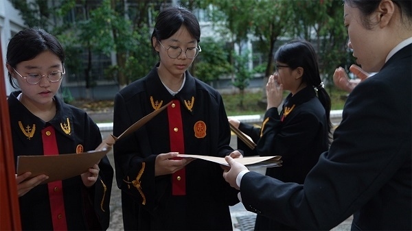 圖①：武平法院干警向?qū)W生分發(fā)道具卷宗。