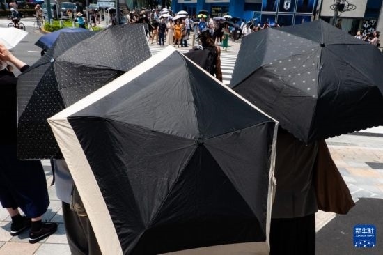 7月4日，人們?cè)谌毡緰|京原宿的街道上等待紅綠燈。新華社記者 張笑宇 攝