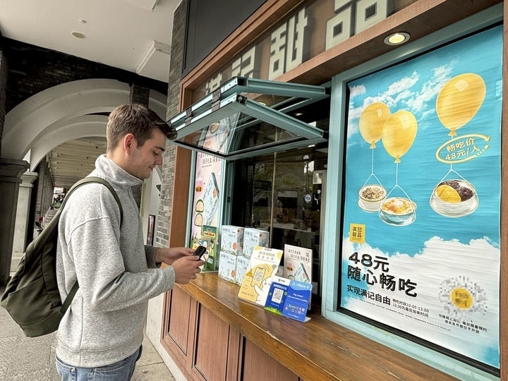 來自德國的留學生理查德在杭州西湖邊一家商鋪使用支付寶掃碼支付（2024年4月11日攝）。新華社發(fā)