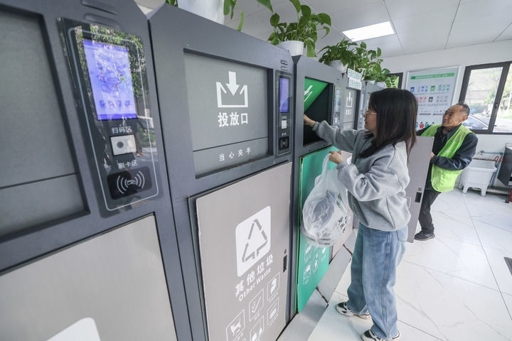 2024年4月10日，在浙江省湖州市吳興區(qū)飛英街道新華府小區(qū)內(nèi)，居民在垃圾分類智能系統(tǒng)的指導(dǎo)下進(jìn)行垃圾分類投放，居民的投放情況將實(shí)時(shí)匯總到智慧服務(wù)平臺(tái)，會(huì)有相應(yīng)的積分獎(jiǎng)勵(lì)。新華社記者 徐昱 攝