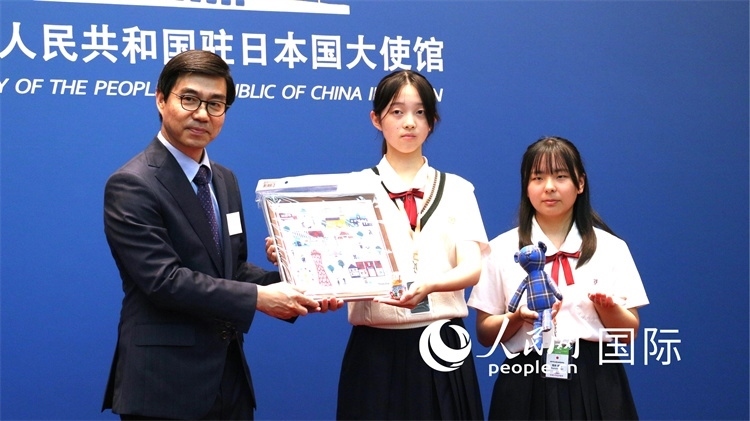 日本小大使向中國駐日本大使館臨時(shí)代辦施泳贈(zèng)送當(dāng)?shù)靥厣Y品。人民網(wǎng) 許可攝