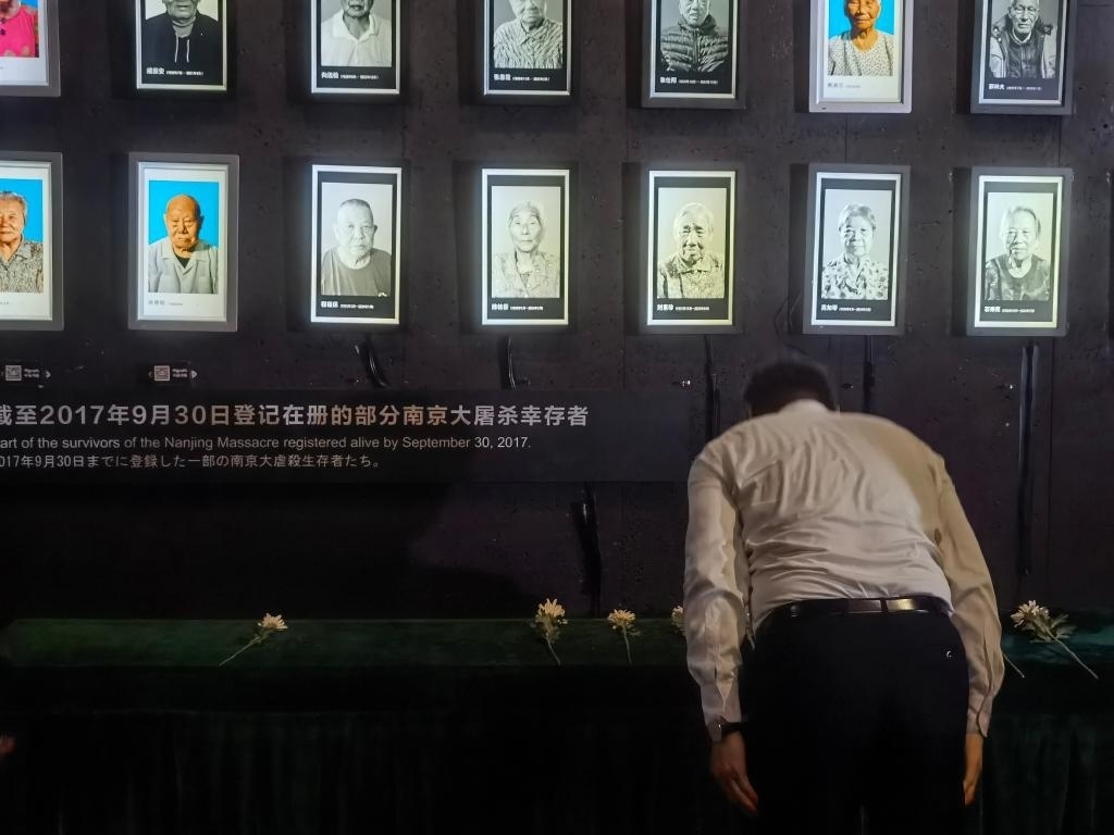 7月18日，人們向離世的南京大屠殺幸存者獻(xiàn)花、鞠躬。新華社記者邱冰清 攝