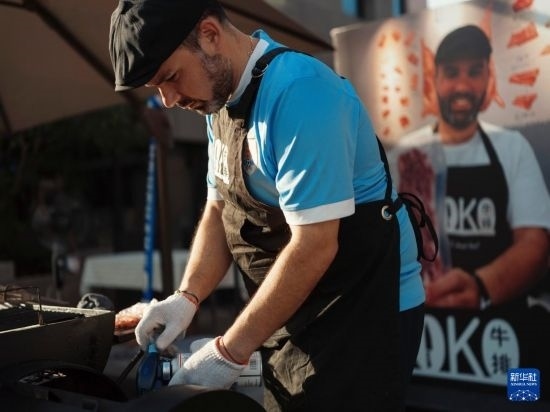 7月19日，在蕪湖古城，馬丁在當(dāng)天舉行的啤酒節(jié)上制作牛排。新華社發(fā)（繆雨晨 攝）