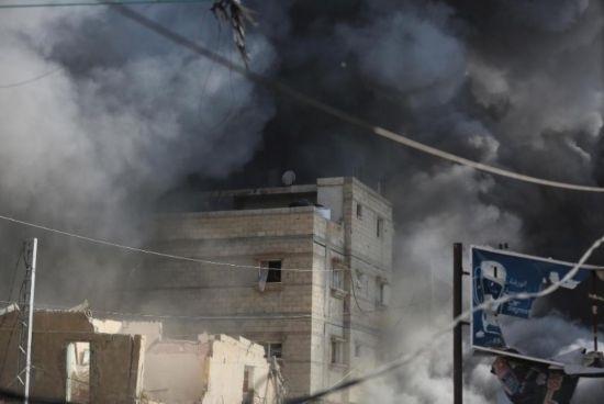 7月21日，在加沙地帶中部的努賽賴特難民營(yíng)，遭以軍空襲的建筑冒出滾滾濃煙。新華社發(fā)（馬爾萬(wàn)·達(dá)烏德攝）