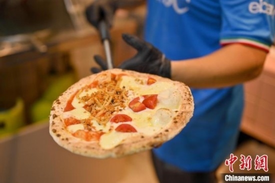 近日，韋榮耀展示他制作的“老友味”披薩。 俞靖 攝
