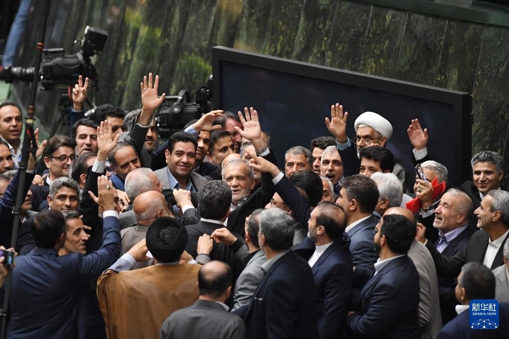 7月30日，在伊朗德黑蘭的伊朗議會(huì)，佩澤希齊揚(yáng)（中）離開(kāi)總統(tǒng)就職典禮現(xiàn)場(chǎng)時(shí)揮手致意。新華社記者 沙達(dá)提 攝