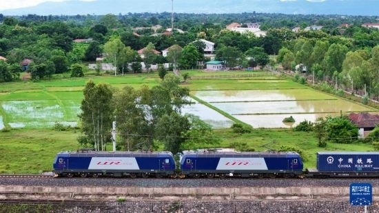 8月5日，由老撾籍火車司機(jī)獨(dú)立駕駛的滿載貨物的列車駛出萬象站，向中國昆明進(jìn)發(fā)（無人機(jī)照片）。新華社發(fā)（楊永全 攝）