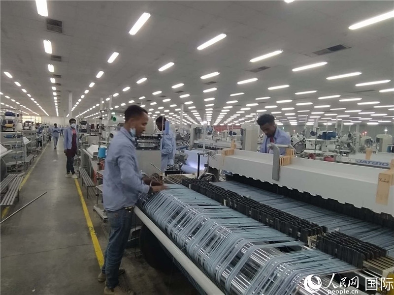 無(wú)錫金茂埃塞面料廠車間內(nèi)，當(dāng)?shù)毓と苏谝唤z不茍地作業(yè)。人民網(wǎng)記者 黃培昭攝