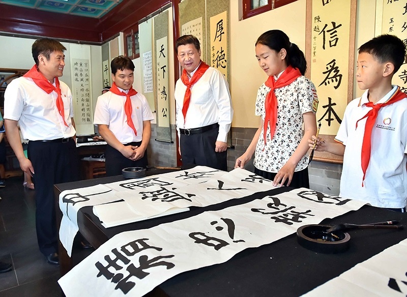 2014年5月30日，習(xí)近平總書記來到北京市海淀區(qū)民族小學(xué)，參加慶?！傲弧眹H兒童節(jié)活動。這是總書記觀看學(xué)生書寫的毛筆字。
