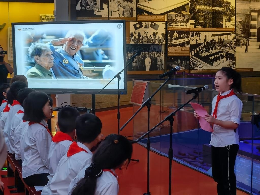 南京市科睿小學(xué)二年級學(xué)生章若初為大家講述抗戰(zhàn)老兵手印的故事。 新華社記者 邱冰清 攝