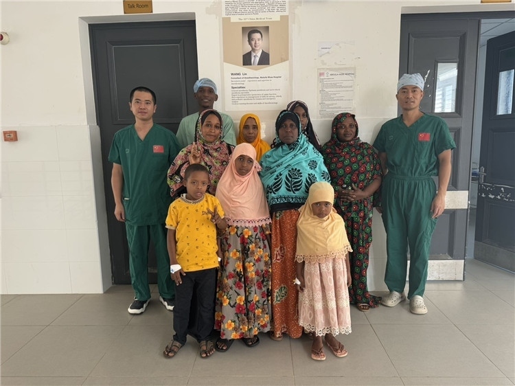 李廣（右一）和王林醫(yī)生與部分患者合影。中國(guó)援桑醫(yī)療隊(duì)供圖