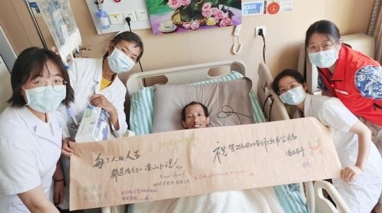 7月26日，海淀醫(yī)院安寧療護(hù)科醫(yī)護(hù)團(tuán)隊(duì)為朱銳送來(lái)一條寫滿祝福的橫幅。（受訪者供圖）