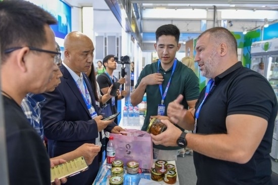 2023年8月23日，在第十四屆中國—東北亞博覽會(huì)東北亞商品館，俄羅斯參展商向參觀者介紹商品。