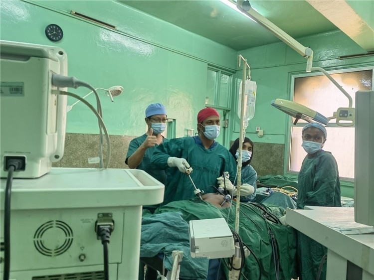 隊長蔣國慶（左一）關注當?shù)蒯t(yī)生手術情況。中國援桑醫(yī)療隊供圖