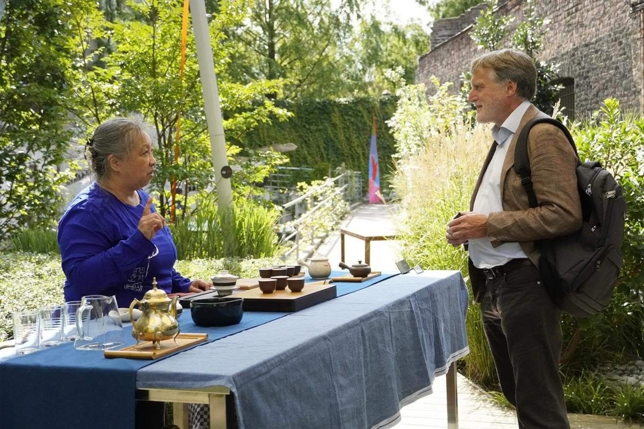 在博物館的戶外花園來賓品味中國茶藝。比利時維他命文化傳媒供圖