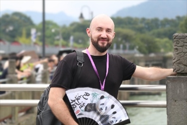 俄羅斯塔斯社執(zhí)行編輯葉夫根尼·扎多羅日內(nèi)在都江堰魚嘴拍照留念。（李佩藺 攝）