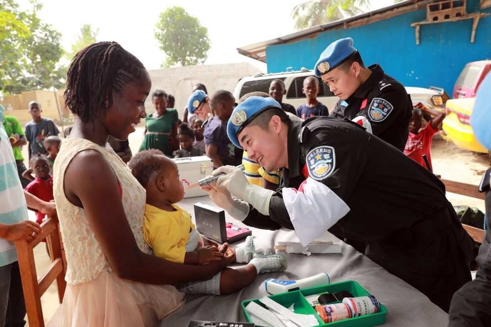 2017年12月28日，在利比里亞蒙羅維亞，中國維和警察防暴隊(duì)醫(yī)療人員為兒童做口腔檢查。