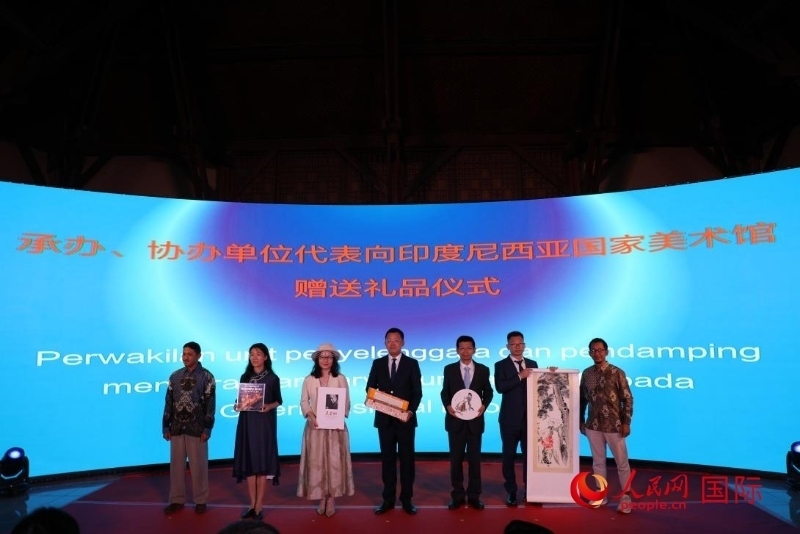 在展覽開幕式現(xiàn)場，本次展覽的承辦、協(xié)辦單位代表向印尼國家美術館贈送禮品。人民網記者 曹師韻攝