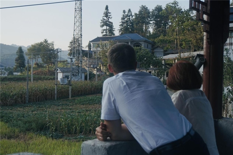 望得見(jiàn)山，看得見(jiàn)水，記得住鄉(xiāng)愁。每個(gè)人心中都有一個(gè)屬于自己的“花茂村”，在這方心田，走遍千山萬(wàn)水，鄉(xiāng)音未改鬢毛衰。吉爾吉斯斯坦《比什凱克晚報(bào)》第一副總編輯妮娜·尼奇博洛娃與《中國(guó)與俄羅斯》雜志社社長(zhǎng)奧列格·別列日內(nèi)赫攝在花茂村民居屋檐下并肩佇立，眺望山水，尋覓鄉(xiāng)愁。（李光裕攝）