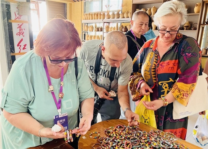 歐亞媒體考察團(tuán)成員在母氏陶藝館內(nèi)挑花了眼，色彩絢麗、質(zhì)地均勻的陶藝手串讓他們愛(ài)不釋手?！斑@里的東西都太實(shí)惠了！”塔吉克斯坦《索格特真理報(bào)》政論部主任娜塔利婭·多羅費(fèi)耶娃說(shuō)?；宓奶厣a(chǎn)品物美價(jià)廉，讓考察團(tuán)成員為家人好友買到了心儀的禮物，也為此次以四川成都為起點(diǎn)，路經(jīng)南充、廣安至貴州遵義的考察行程畫上了圓滿句號(hào)。（張亞欣攝）