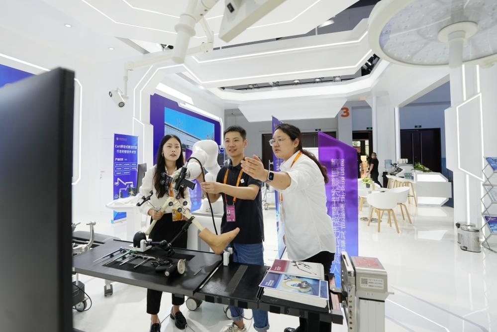 9月11日，一位媒體記者（中）在2024年服貿(mào)會國家會議中心會場體驗(yàn)北京納通科技集團(tuán)有限公司的膝關(guān)節(jié)置換手術(shù)機(jī)器人。新華社記者鞠煥宗 攝