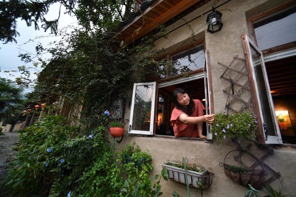 8月29日，在福建省屏南縣熙嶺鄉(xiāng)，龍?zhí)洞濉靶麓迕瘛泵泛暝诖蚶碜约航?jīng)營的民宿外墻裝飾花盆。新華社記者姜克紅 攝