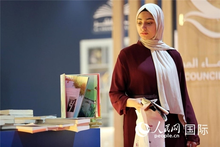 一名女性走過展臺。人民網(wǎng) 奧馬爾·哈利勒攝