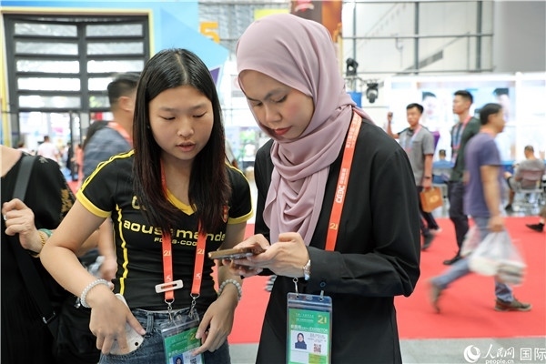 東博會(huì)現(xiàn)場，馬來西亞展商在同中方工作人員交談。人民網(wǎng)記者 趙益普攝