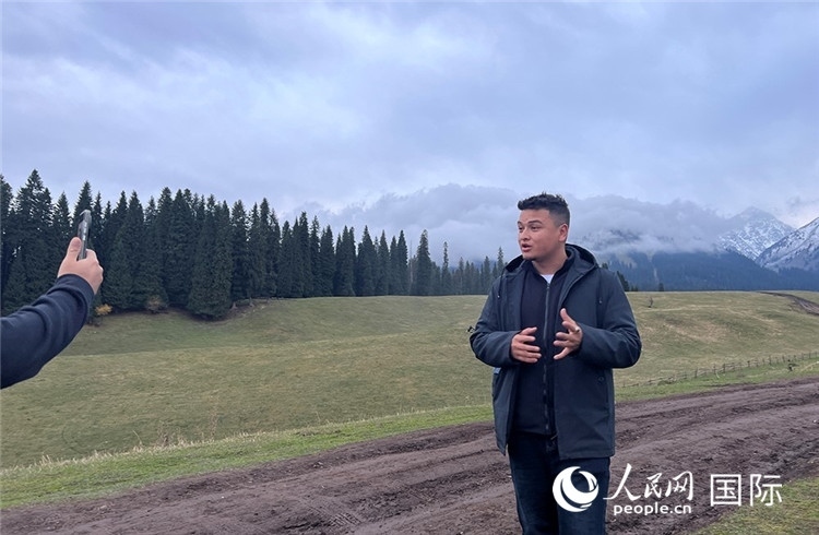 在庫(kù)爾德寧，吾買爾江被雪山美景震撼，即興錄制了短視頻作品。人民網(wǎng)記者曾書柔攝