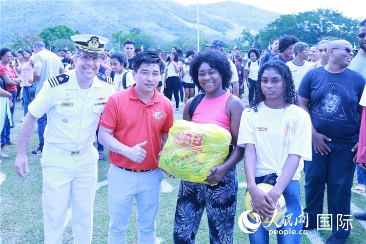 巴西中國浙江商會會長鄭俠茂向巴西貧困社區(qū)兒童及家庭捐贈基礎(chǔ)食品籃子和足球。人民網(wǎng)記者陳海琪 攝