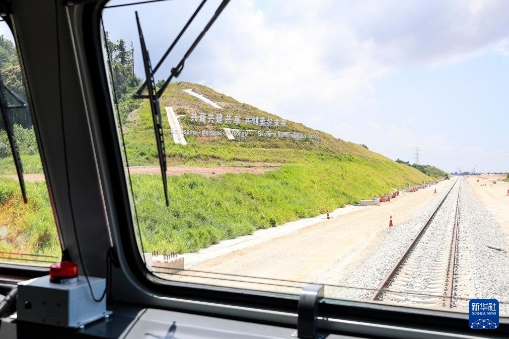 5月6日，在馬來西亞彭亨州馬東鐵項(xiàng)目沿途的山坡上，兩行中文和馬來文大字“共商共建共享，共創(chuàng)美好未來”映入眼簾。新華社記者 程一恒 攝