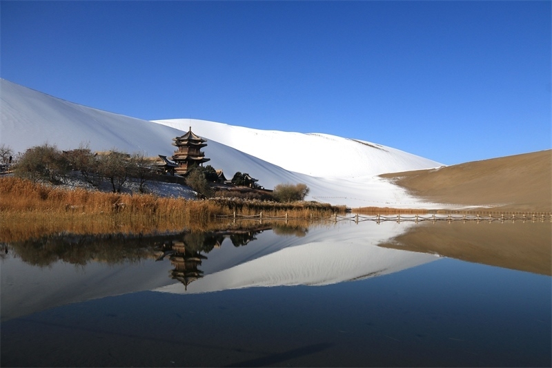 鳴沙山月牙泉景區(qū)雪景。敦煌市委宣傳部供圖，張曉亮攝
