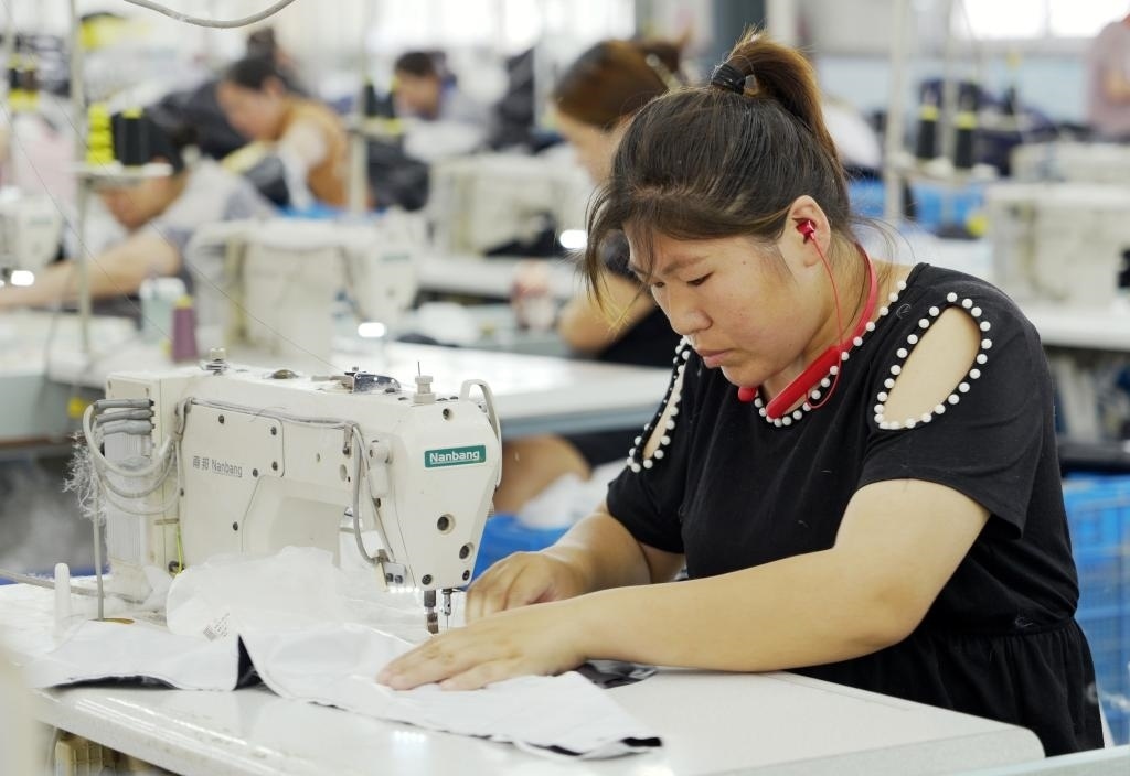 5月20日，村民在李寨村服裝加工廠內(nèi)忙碌。河南省周口市沈丘縣馮營(yíng)鎮(zhèn)李寨村地處豫東平原。近年來(lái)，乘著脫貧攻堅(jiān)與鄉(xiāng)村振興政策的東風(fēng)，李寨村積極探索產(chǎn)業(yè)發(fā)展模式，通過(guò)“龍頭企業(yè)+村集體經(jīng)濟(jì)+農(nóng)戶”的方式，逐漸發(fā)展形成肉牛養(yǎng)殖、設(shè)施農(nóng)業(yè)、服裝加工、康養(yǎng)民宿等產(chǎn)業(yè)，以產(chǎn)業(yè)振興助力鄉(xiāng)村振興。新華社記者 李嘉南 攝