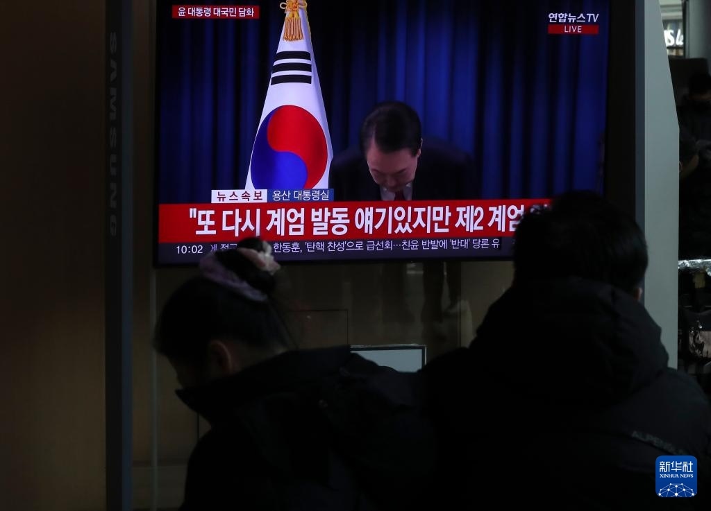 12月7日，在韓國(guó)首爾火車站，民眾觀看總統(tǒng)尹錫悅發(fā)表講話的電視畫面。新華社記者 姚琪琳 攝