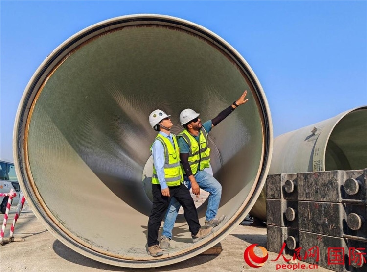 工作人員在察看輸水管情況。人民網(wǎng)記者 管克江攝