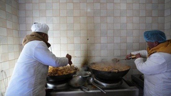1月14日，服務(wù)隊(duì)的兩名廚師正在為村民們做午飯。新華社記者 邱星翔 攝