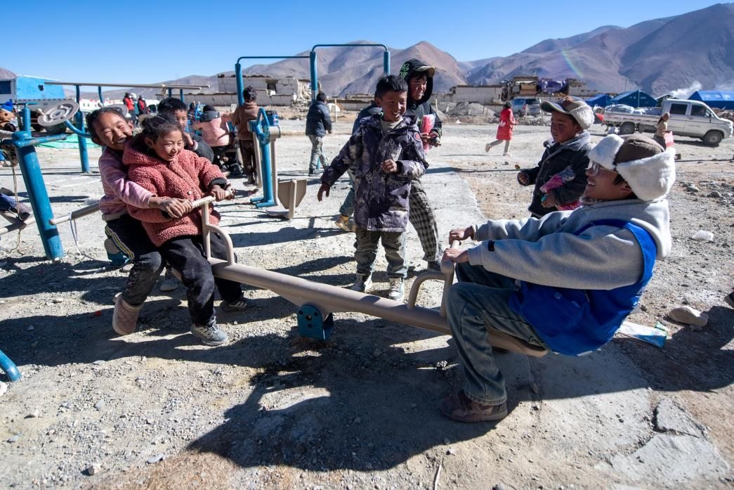 1月11日，在定日縣措果鄉(xiāng)塘仁村安置點(diǎn)，西藏星光社會工作服務(wù)中心志愿者和孩子們一起玩耍，進(jìn)行災(zāi)后心理疏導(dǎo)。人民網(wǎng)記者 翁奇羽攝