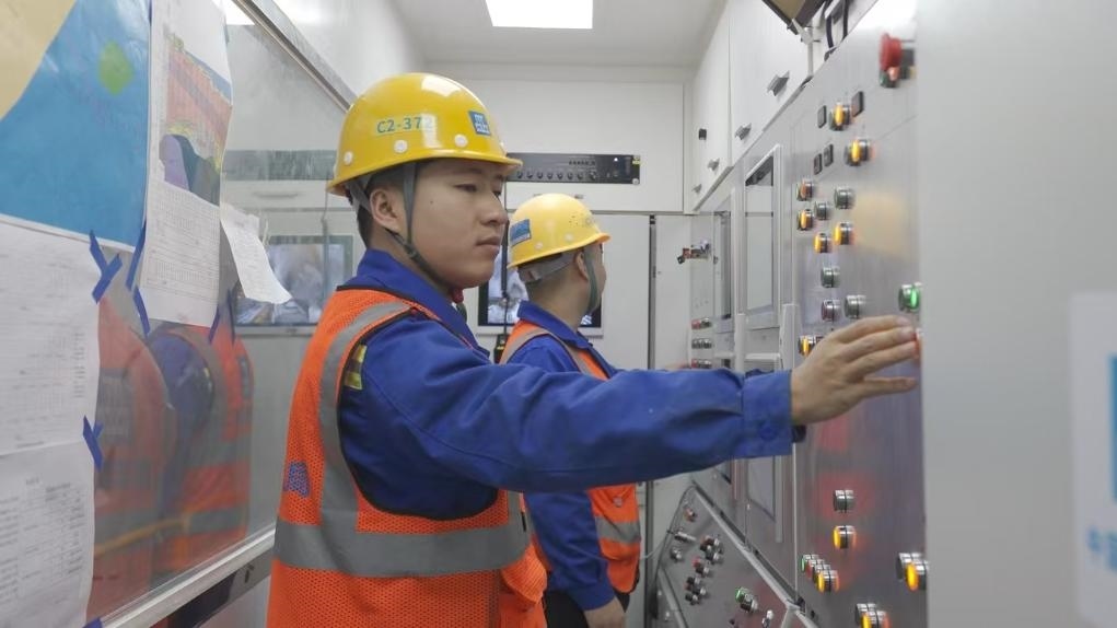 盾構司機何曉波在駕駛室內(nèi)調(diào)試盾構機參數(shù)。（劉芬攝）