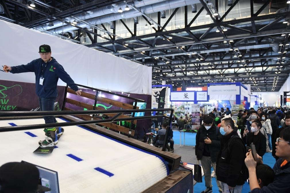 2023年2月11日，參觀者在展會上了解一款模擬滑雪設(shè)備。當日，2023亞洲運動用品與時尚展在國家會議中心拉開帷幕。新華社記者 張晨霖 攝