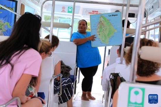 3月15日，一名導(dǎo)游在游艇上為游客介紹塞舌爾拉迪格島。新華社記者 董江輝 攝