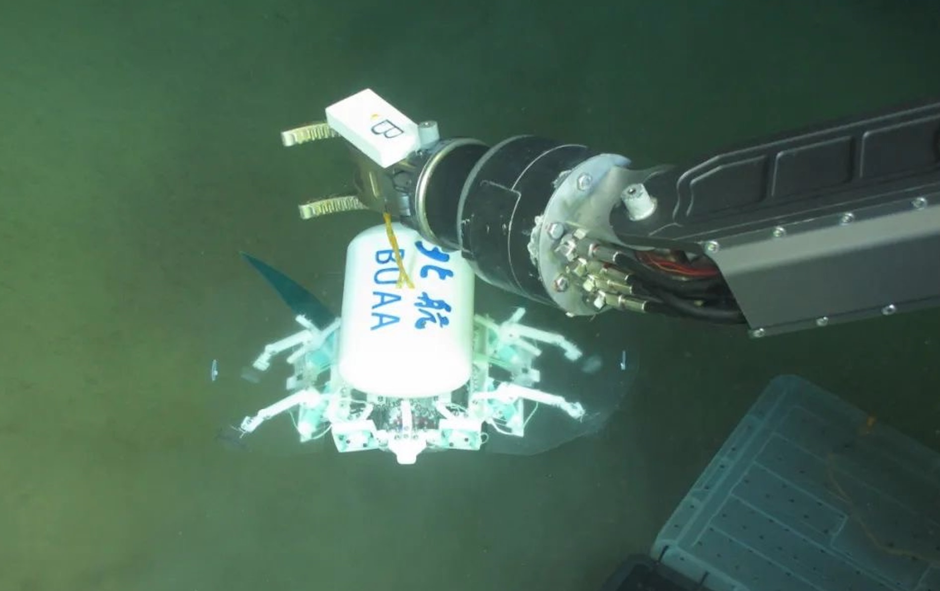 科研人員利用機(jī)械臂將北航深海小型機(jī)器人投于馬里亞納海溝。校方供圖