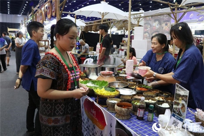 游客在攤位前購買特色美食。朱瀟逸攝