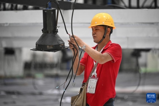 4月4日，工作人員在海南國(guó)際會(huì)展中心內(nèi)布設(shè)燈光。