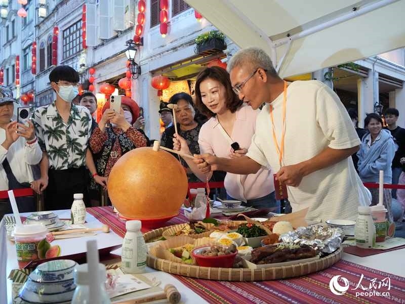 嘉賓品嘗海南傳統(tǒng)美食“煎堆”。人民網(wǎng)記者 張力洋攝