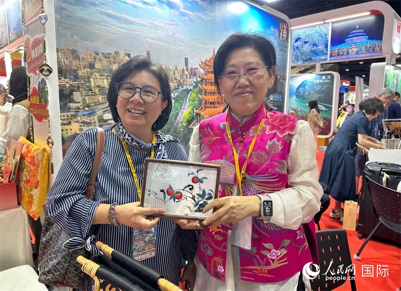 中國(guó)“大冶刺繡”傳承人劉小紅（右）參加泰國(guó)國(guó)際旅游展，向觀眾介紹中國(guó)非遺刺繡針?lè)?。人民網(wǎng)記者 簡(jiǎn)承淵攝
