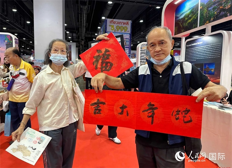 2025蛇年春節(jié)，泰國(guó)市民展示他們領(lǐng)到的華人手寫(xiě)春聯(lián)。人民網(wǎng)記者 簡(jiǎn)承淵攝
