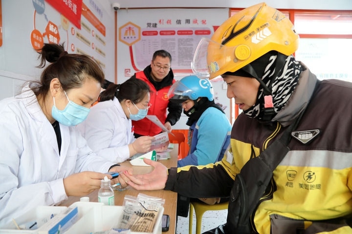 2025年3月5日，志愿者在山東省棗莊市市中區(qū)一工會驛站為外賣員免費測量血糖。新華社發(fā)（王海楠攝）