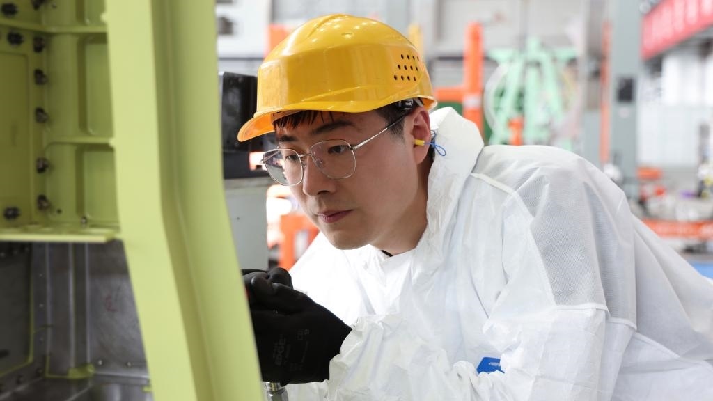 在中國(guó)航空工業(yè)集團(tuán)成飛車(chē)間內(nèi)，飛機(jī)鉚裝鉗工首席操作技師馮攀龍正在工作。（新華社發(fā)）